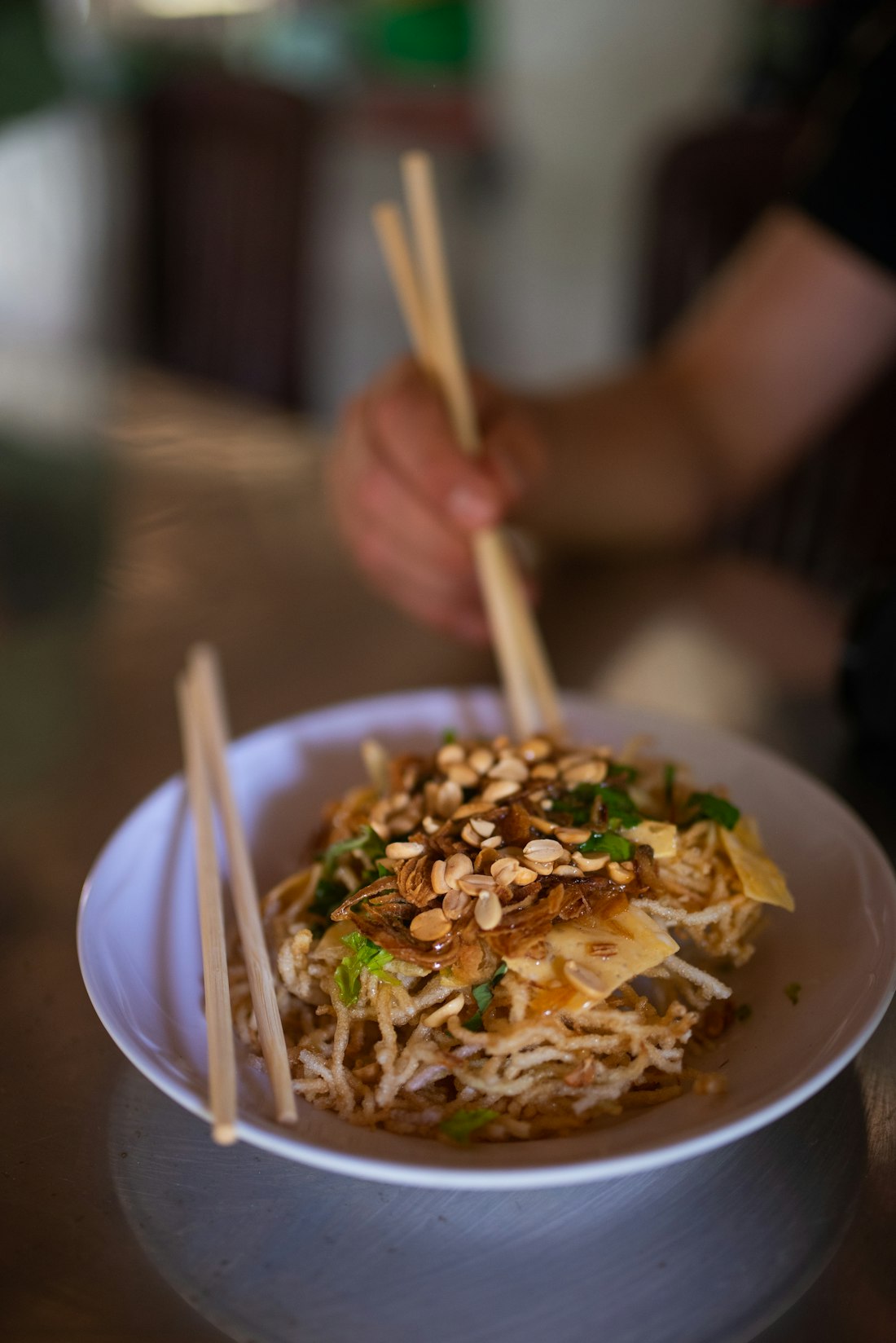 A vibrant street food scene in Vietnam — small stools, low tables, steaming bowls